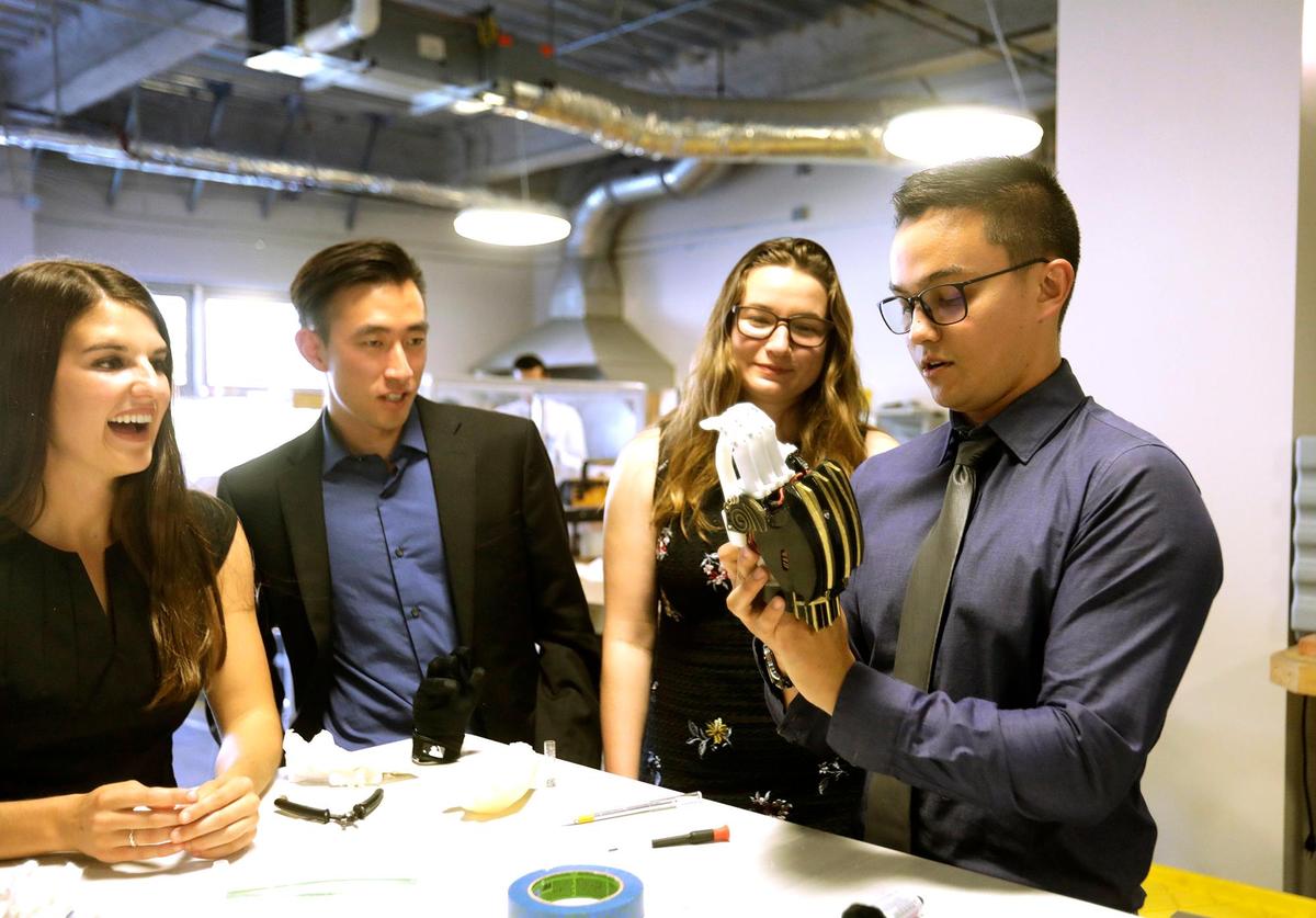 Cal Poly engineering students, from left, Rachael Peabler, Bryson Chan, Janis Iourovitski and Austin Conrad look over the prosthetic hand.