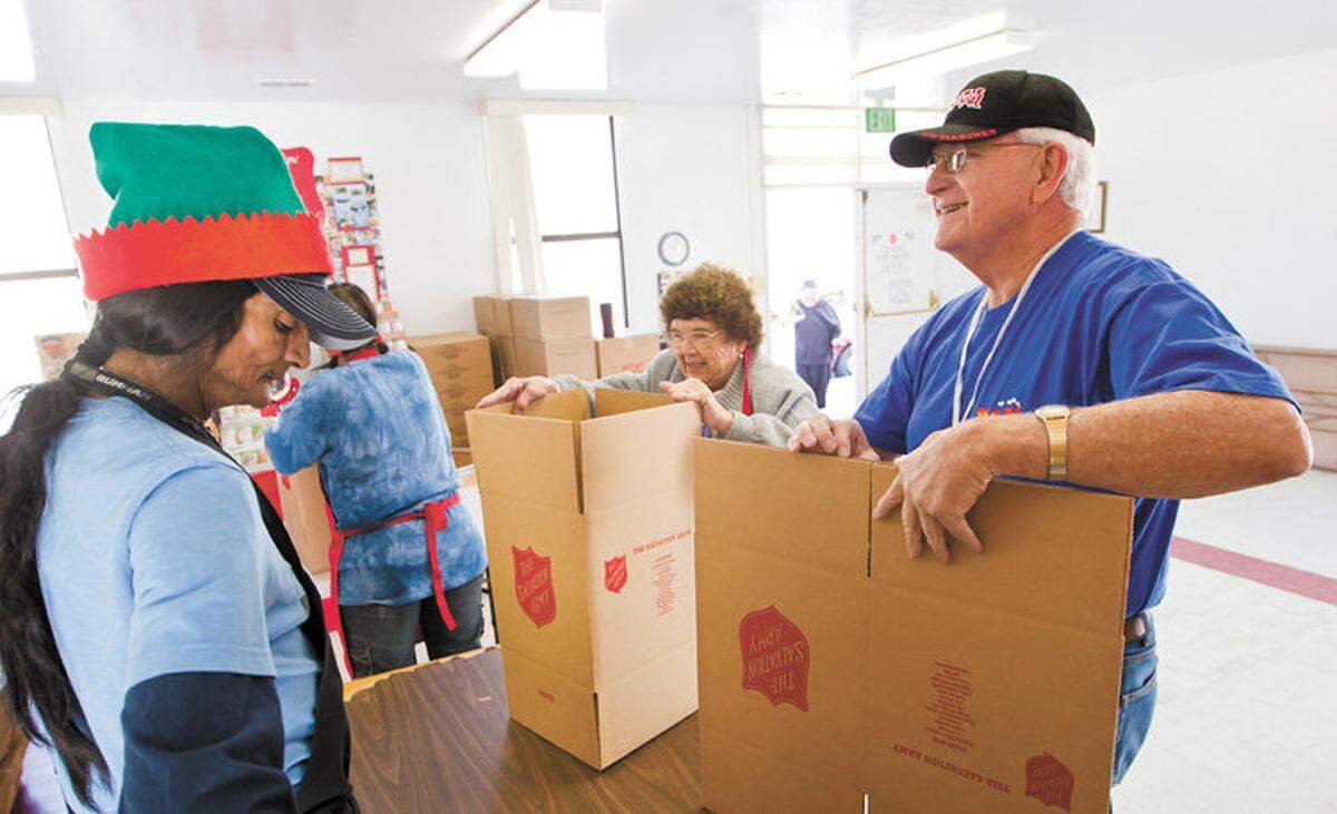 John Muller, right, volunteer for Toys for Tots, works with Peter Zepeda,left, and Marie Wilson,center, at the Salvation Army in SLO.