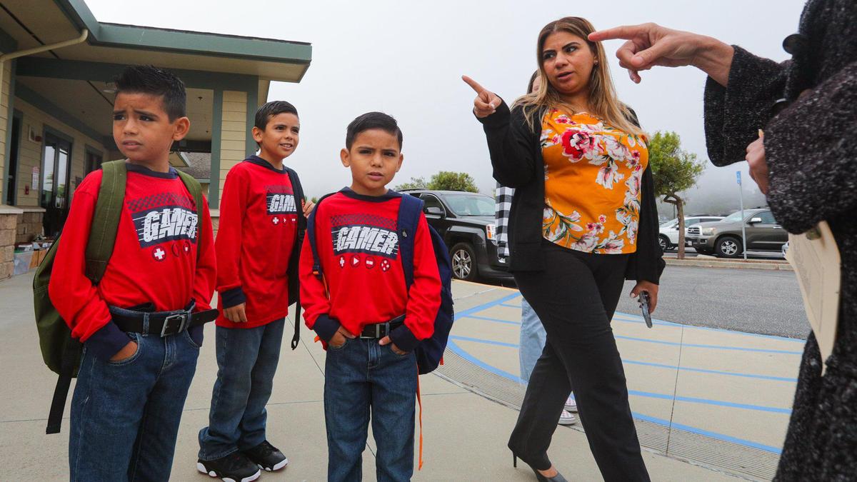 Brothers Gael, 7, Gerardo, 10, and Gared Medina, 6, sort out their class assignments with Cynthia Padilla and principal Jill Southern. Students returned for the school year at Cambria Grammar School Aug 16, 2022.