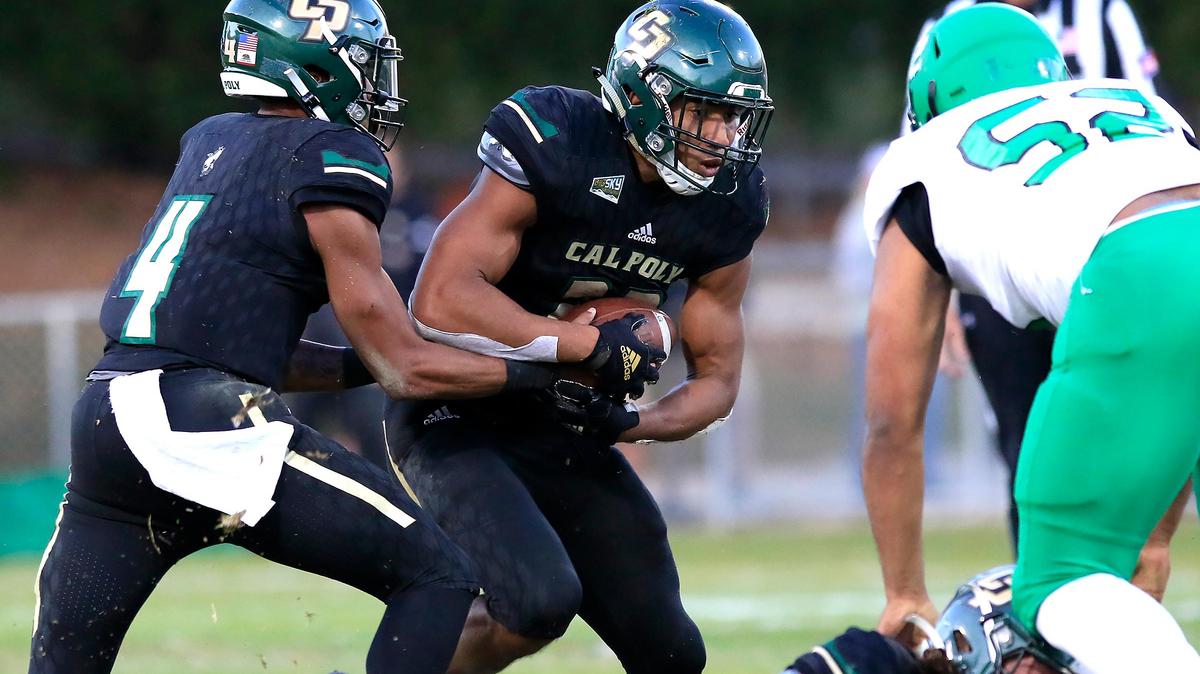 Cal Poly’s Duy Trans-Sampson (22) takes the ball from quarterback Jalen Hamler in an Oct. 12 game against North Dakota. The Mustangs fell to 1-5 in Big Sky Conference play with Saturday’s loss to Idao.