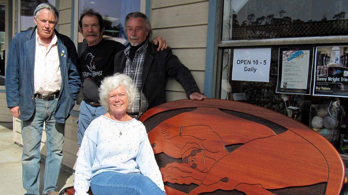 Beth Yudovin relaxes on a new East Village bench in Cambria honoring her late husband, record-setting open-water swimmer David Yudovin. Artisans behind the bench’s creation are, from left, David Plumb, Jay Burbank and Phil Hauser.