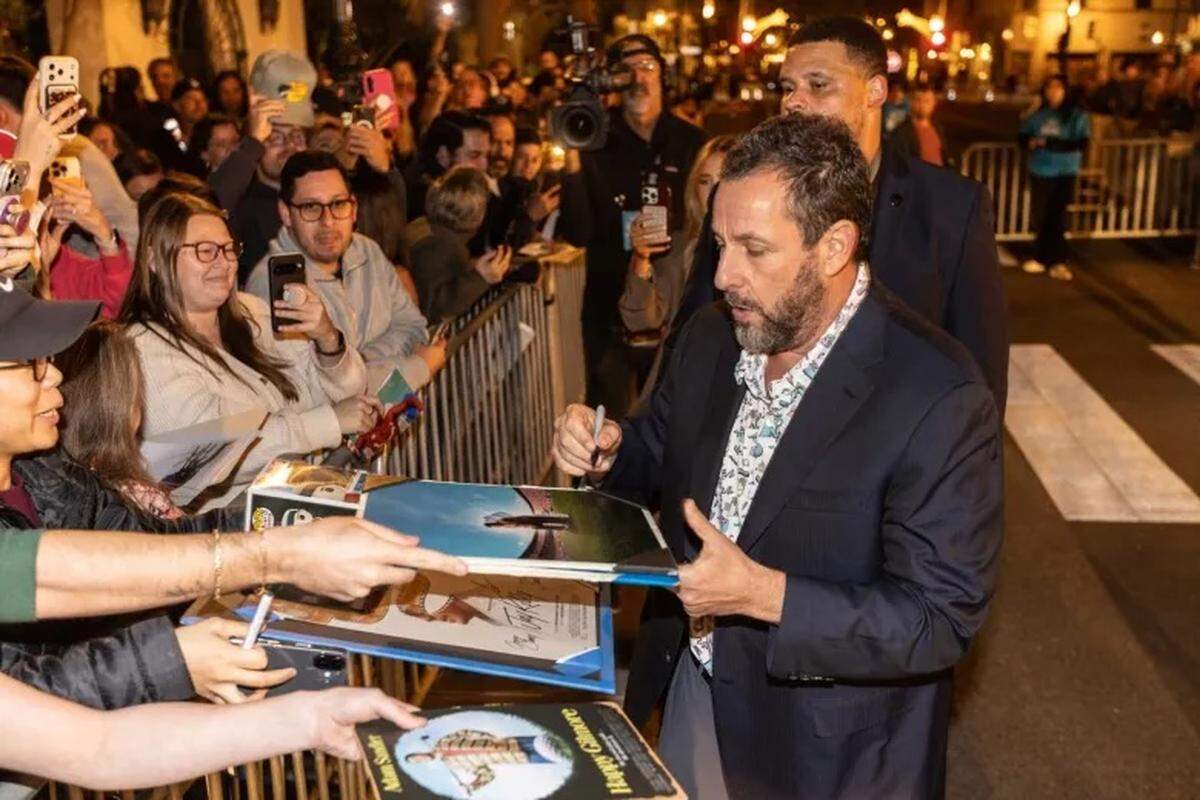 Adam Sandler signs “Happy Gilmore” and “The Waterboy” memorabilia for fans at the Santa Barbara International Film Festival Thursday night.