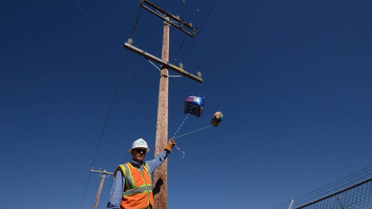 PG&E supervisors Matt Jones holding Mylar metallic balloons.