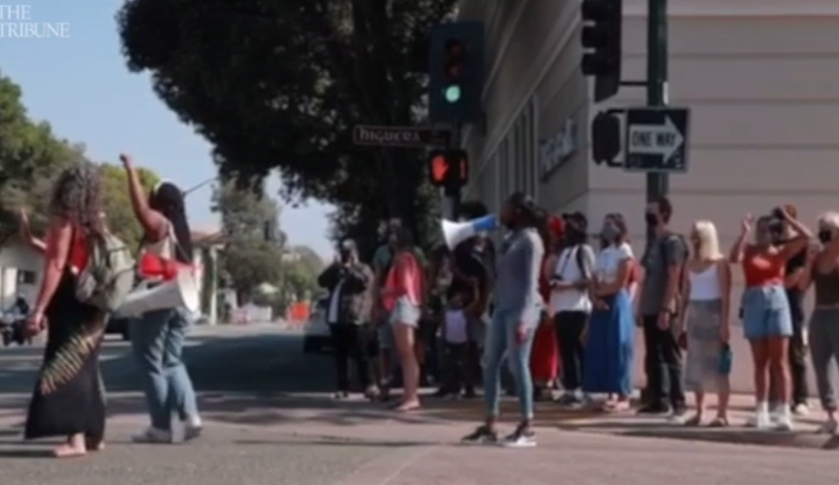 Protesters chant at the corner of Higuera and Osos streets on Wednesday, moments before a motorcyclist drove into two women.