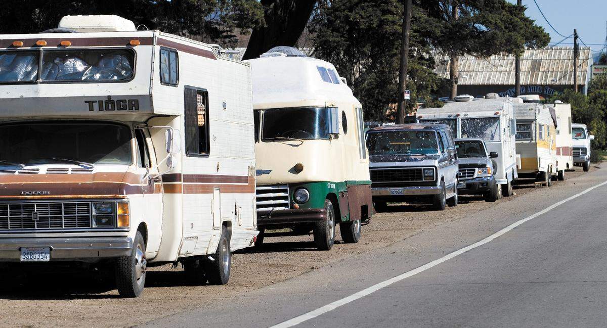 A line of cars on Prado Road, where many homeless gathered to live and sleep in their vehicles. A California bill proposes allowing community college students to sleep in cars on campus.