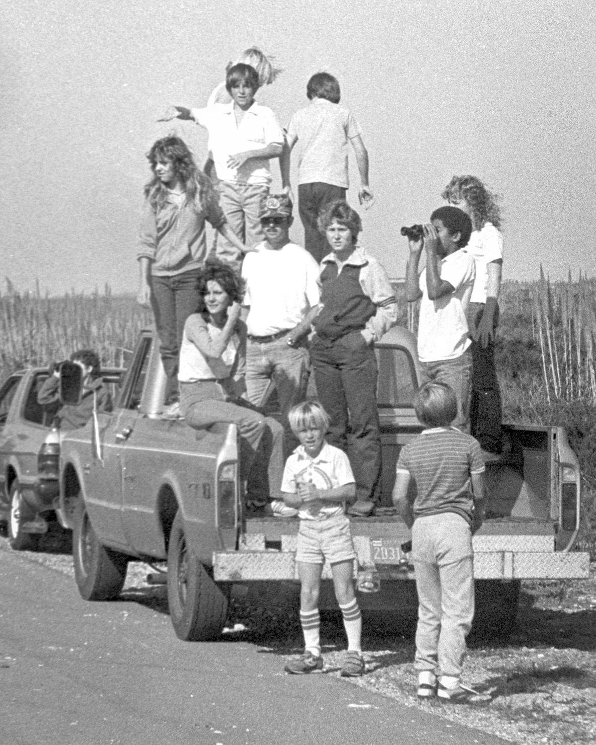 Spectators climb up into back of pickup to watch. The brand new space shuttle Discovery visited Vandenberg Air Force Base on Nov. 6, 1983.