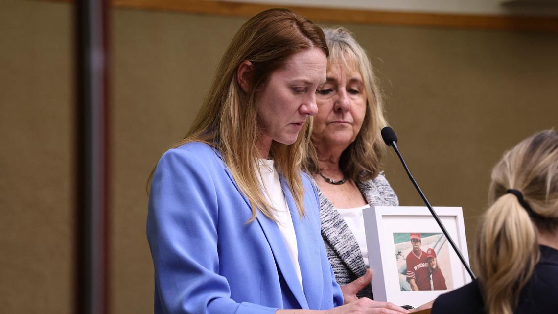 Kelly Owens-Davalos speaks about the loss of her father Glenn Owens and injury of her mother Susan Owens on April 25, 2024, at the sentencing of Patrick W. McDuffee II, who pleaded guilty to second-degree murder for the fatal DUI crash that killed Glenn Owens. At right, victim advocate Dona Reed from the District Attorney’s Office holds a childhood photo of Kelly with her father.