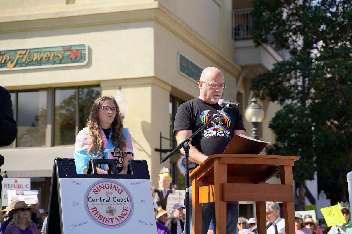 Residents across SLO County rallied downtown at the San Luis Obispo Superior Courthouse for a No Kings protest featuring speakers, music and community groups on March 28, 2026. Arroyo Grande High School student Lily Norcross and father Trevor Norcross speak about trans rights.
