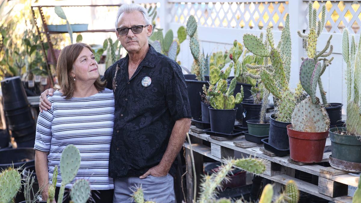 Mary Jane and Bill Jodry have unanswered questions about the death of their son Thomas, who died at the age of 21 in a fall from a San Luis Obispo parking structure five years ago. They continue to advocate for safety improvements to parking structures and for young people to be vigilant when they go out for entertainment. They stand amid an Atascadero cactus sales stand on Sept. 10, 2024, that Thomas had started.