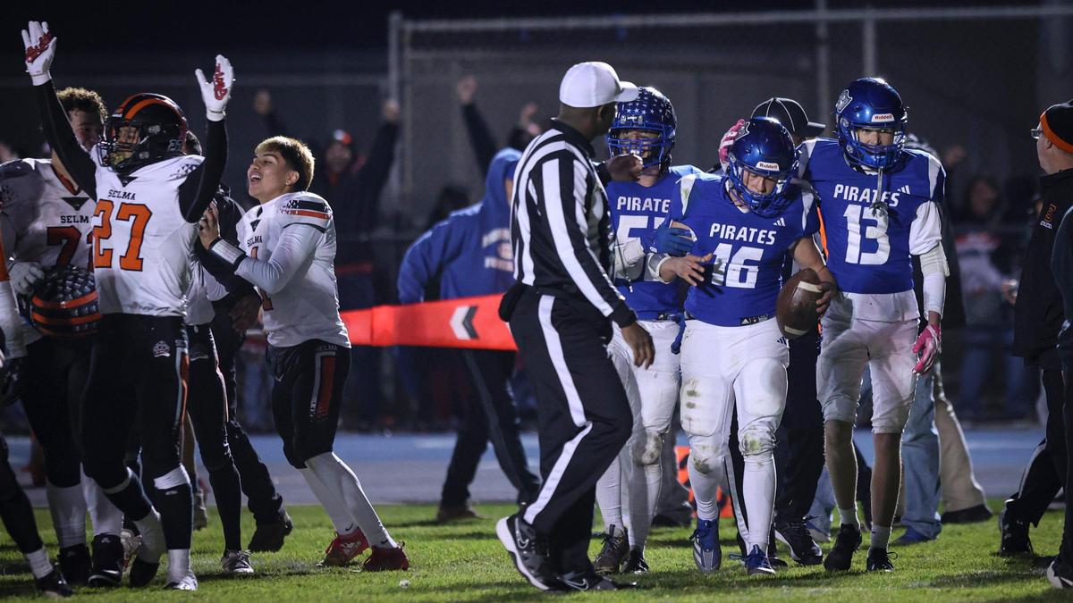 Selma celebrates at left after the last play of the game, Sands Dougherty gets a pat on the helmet from Ryder Busch. Selma held off a last minute drive by Morro Bay to win the CIF Central Section Championship 32-28 on Nov. 27, 2024.