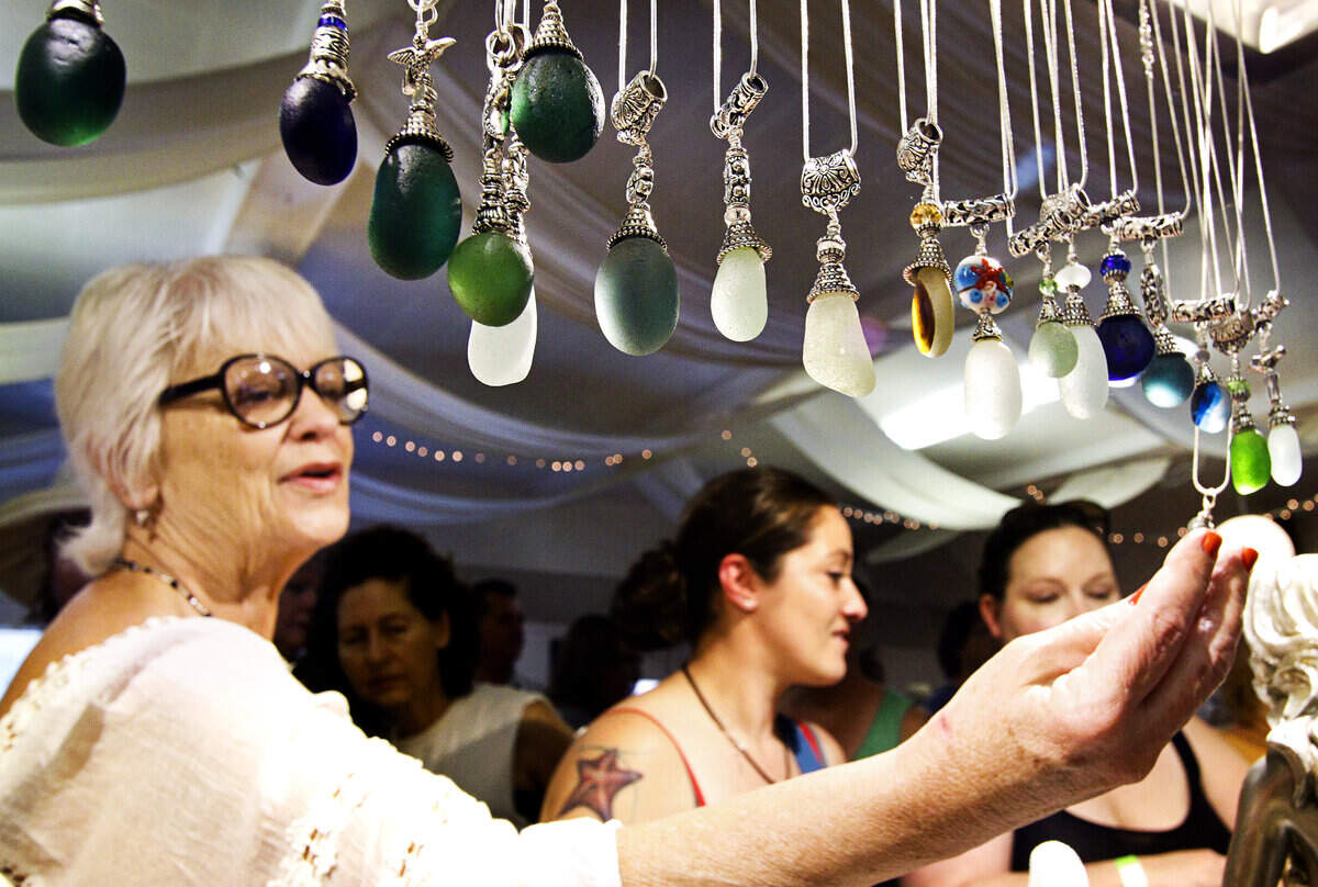 Barbara Bain of Santa Cruz takes a closer look at the sea glass jewelry made by Morro Bay designer Denise Jacobson at the Cayucos Sea Glass Festival in 2015. The 2020 festival has been canceled due to coronavirus concerns.