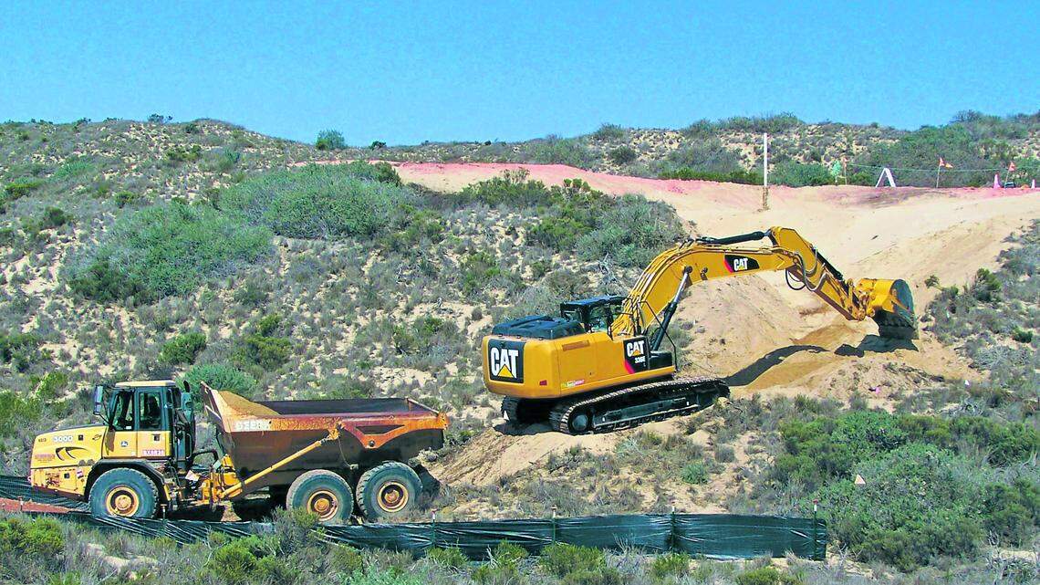 An excavator removes soil at an area called O-5, which was a well pad that was removed and restored in 2014. Most of the vegetation in the foreground is mock heather or lupine, some of which  is dying as a result of the drought and drought-related disease.