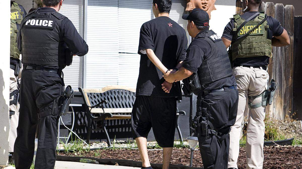 Members of the San Luis Obispo County Gang Task Force and Paso Robles' Special Enforcement Team detain a defendant, who was out on bail, while they search his Paso Robles home for gang-related evidence.