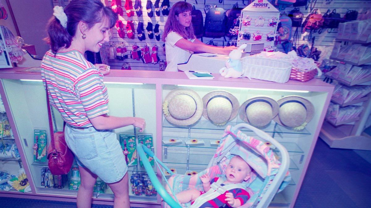 Melanie Meinerts rings up the purchases of Lauren Niezen and son Jake, 5 months, at the relocated Gottschalks Kids in the Central Coast Plaza on June 13, 1995.