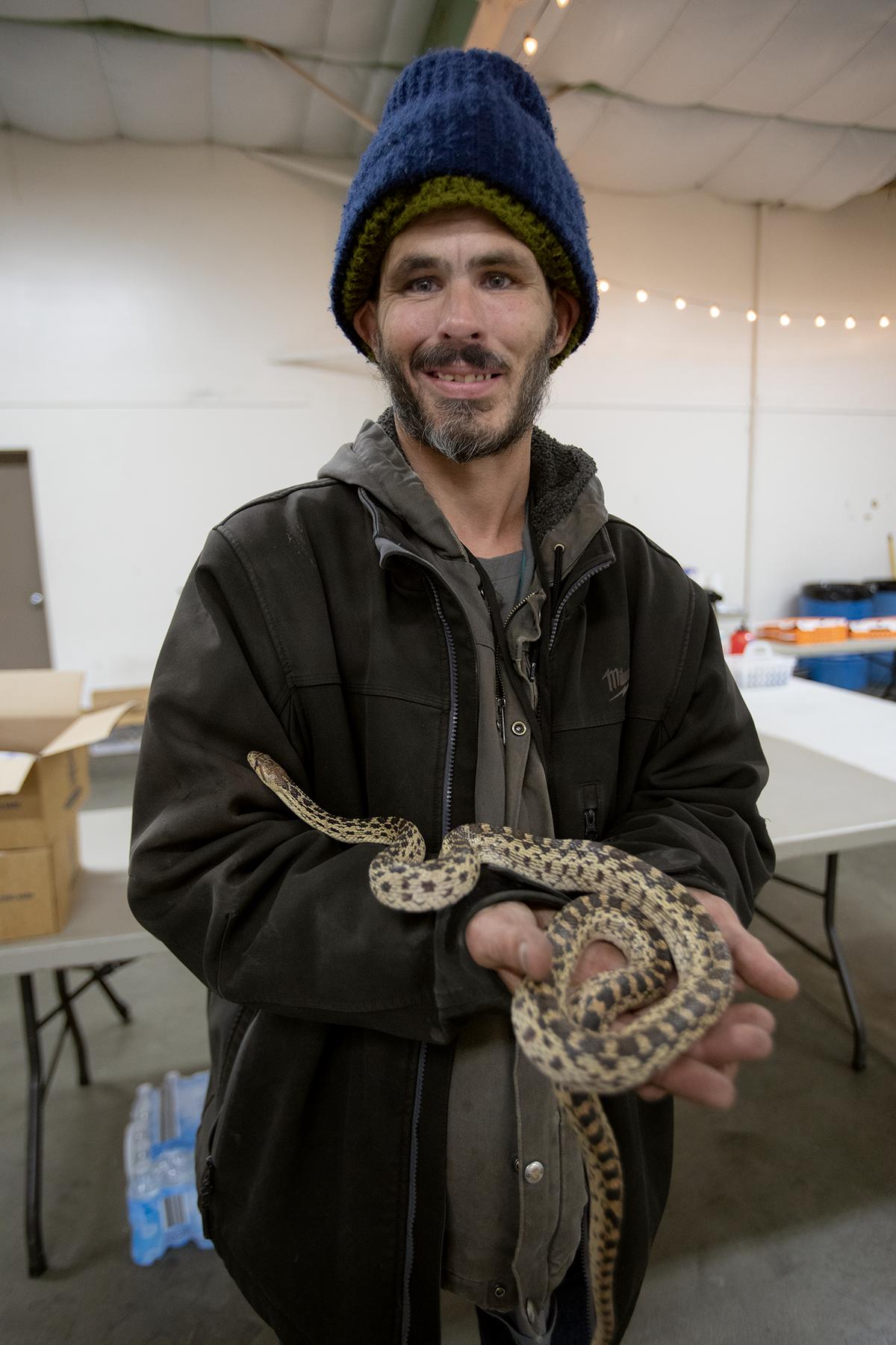 Toby Hurl received some food and supplies for his pet snake Medusa while staying at a warming center set up at the Paso Robles Event Center on Tuesday, Jan. 17, 2023. Local nonprofits partnered with the county to open the temporary North County shelter for unhoused people during the storm.