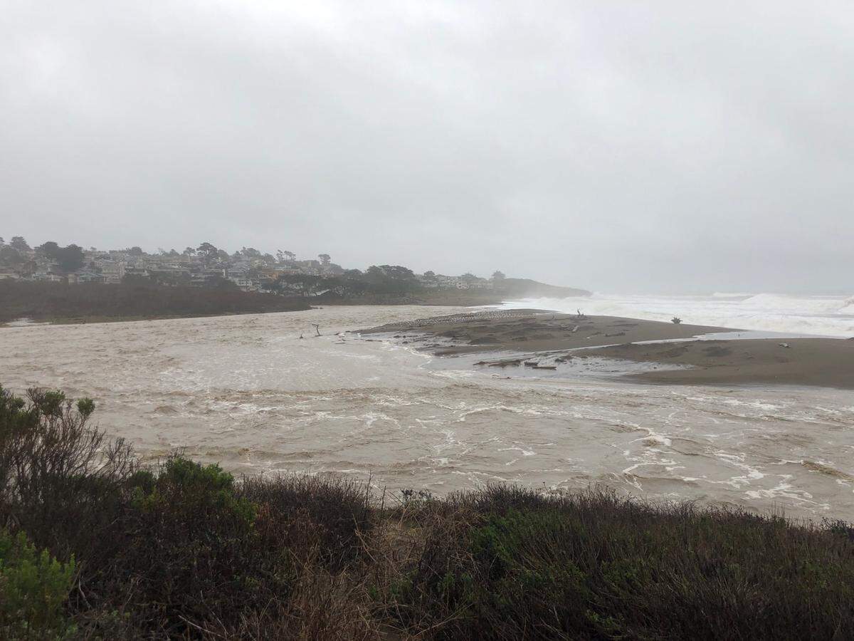 Santa Rosa Creek merges with the ocean near Moonstone Beach due to high swells and rain storm.