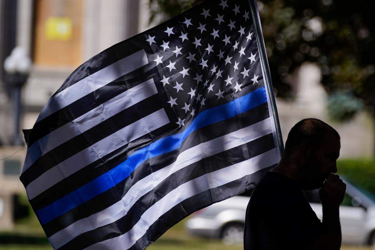 FILE - In this Aug. 30, 2020 file photo, an unidentified man participates in a Blue Lives Matter rally in Kenosha, Wis. University of Wisconsin-Madison’s police chief has banned officers from using “Thin Blue Line” imagery while on duty. The move by Chief Kristen Roman follows criticism on social media of a “Thin Blue Line” flag displayed at the police department’s office. (AP Photo/Morry Gash, File)