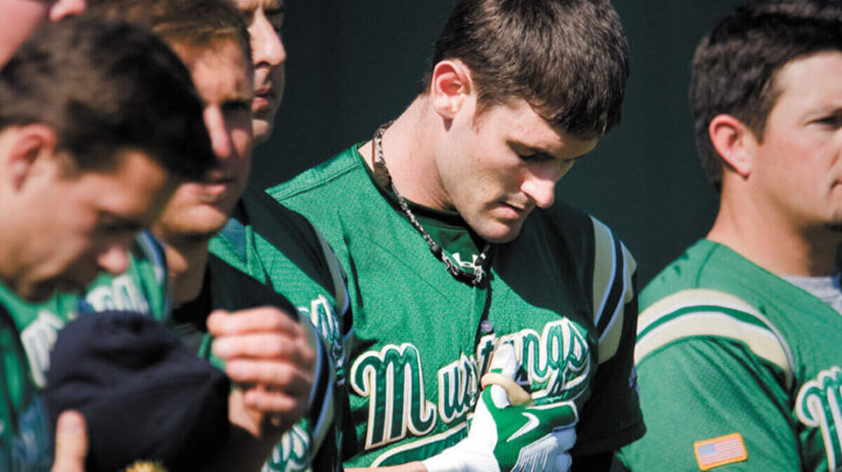 Grant Desme bows his head for the national anthem before playing in the Cal Poly baseball Alumni Game in 2010.