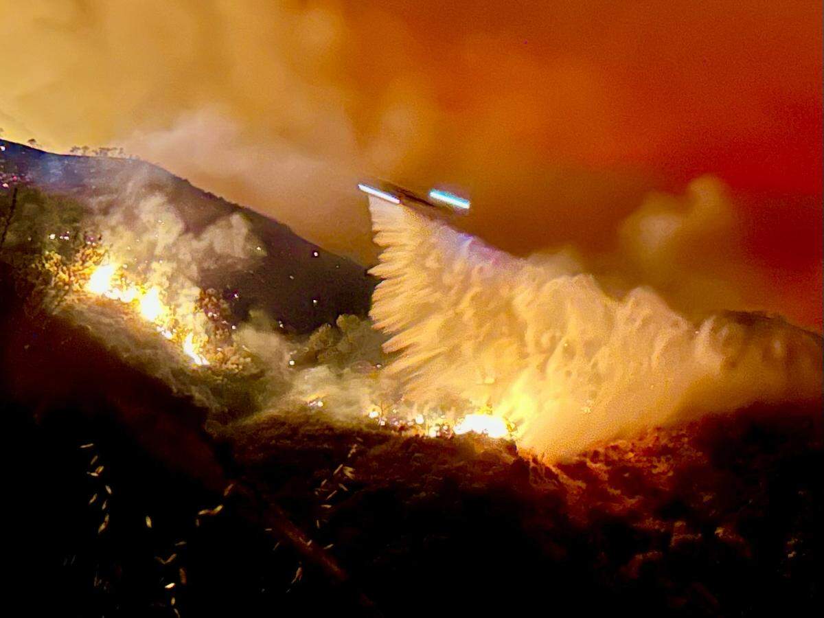 An air tanker does a nighttime water drop on the Gifford Fire on Aug. 7, 2025.