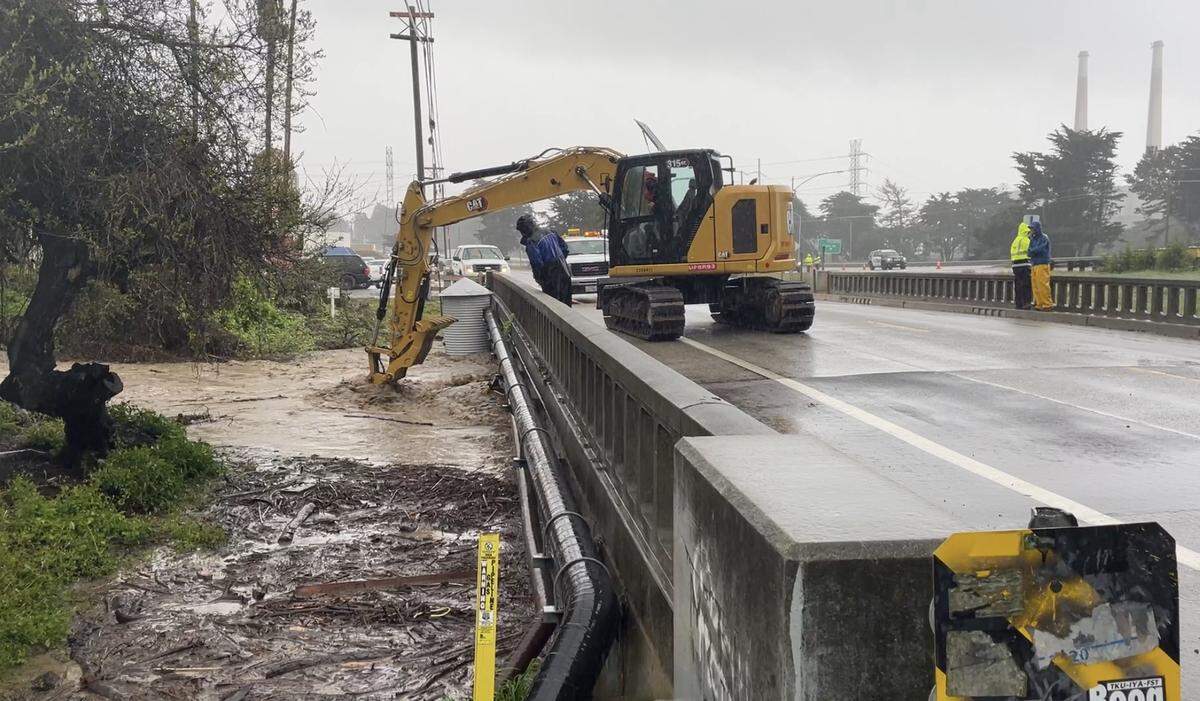 An excavator attempts to remove debris from Morro Creek to prevent it from overflowing the Main Street bridge on March 10, 2023. 