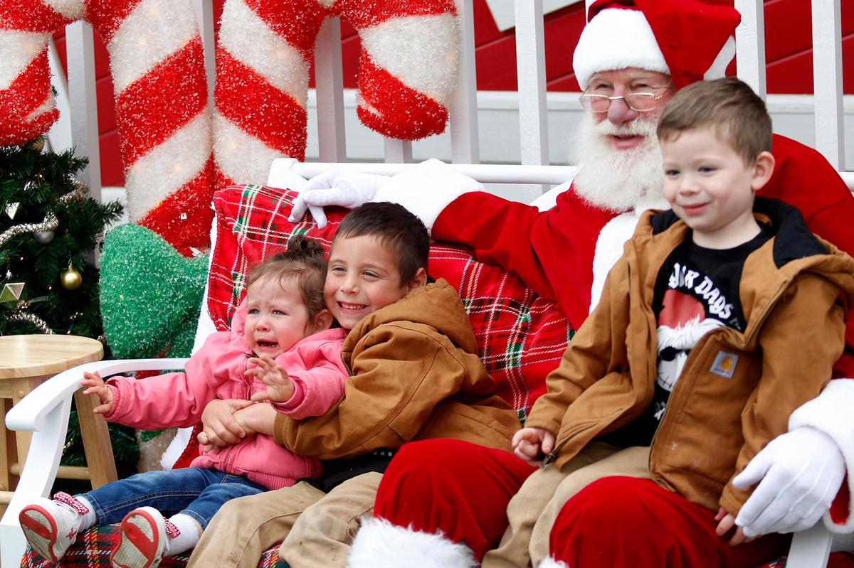 Isabella Navarro reaches for her mother, with brothers Benjamin Navarro, 6 and Joey Navarro, 4. They reside in Oak Glen, California. Joe Schacherer of Oceano, 79, has sat as Santa for 11 years at Downtown SLO’s Santa’s House in Mission Plaza.