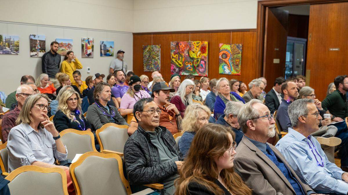 A packed house looked on during a San Luis Obispo City Council study session on introducing a rental registry on Tuesday, Feb. 24, 2026. Realtors opposed to a rental registry wore purple LED necklaces at the meeting, while tenants in support of the registry wore orange.