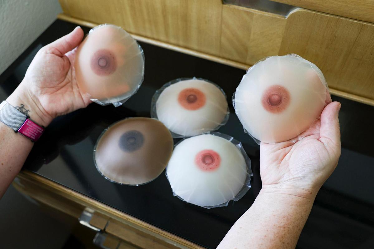 Monica Hollenbeck helps breast cancer survivors heal through her realistic nipple tattooing business, Restored by Ink, in Templeton. Here, she holds silicone demos showing how 3D nipple tattoos can vary in color and detail, helping to camouflage surgery.