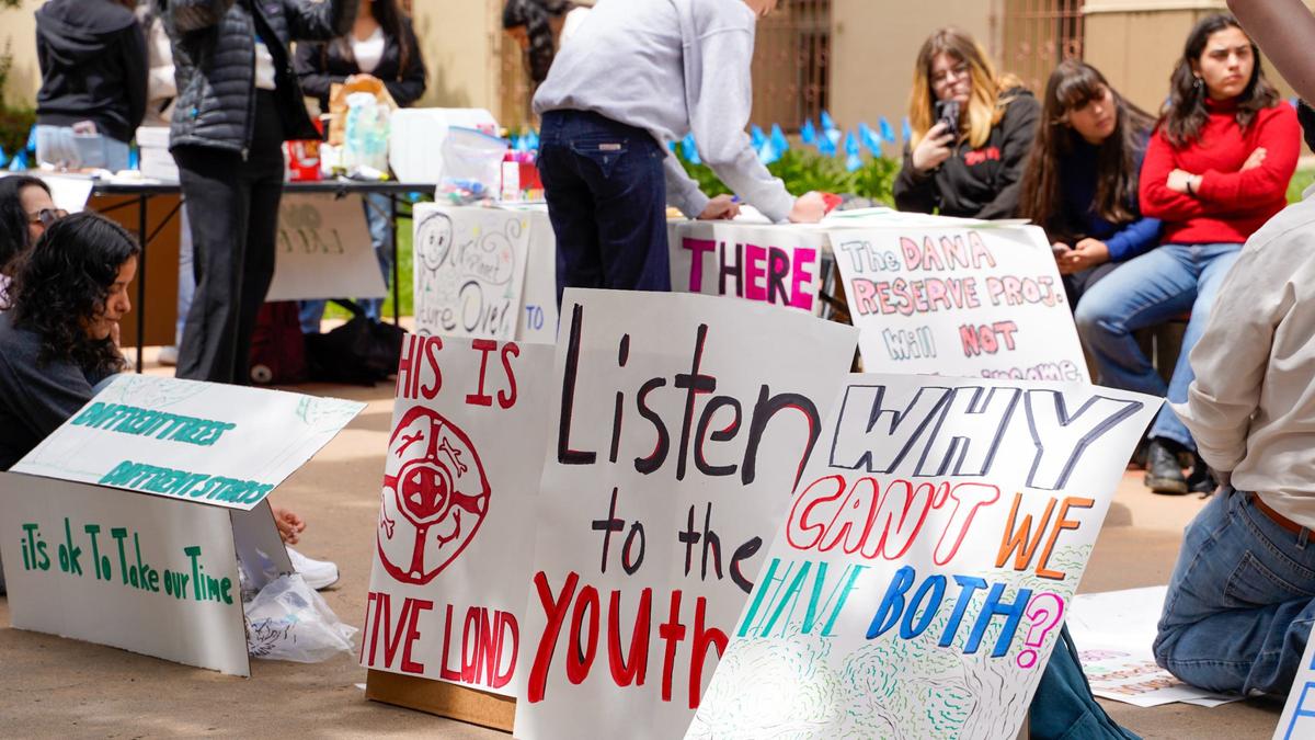 Student protesters with the Central Coast Student Coalition prepare signs for a demonstration against the Dana Reserve housing project Tuesday, April 23, 2024. The Dana Reserve project would add around 1,470 homes to a 288-acre plot of land in Nipomo.