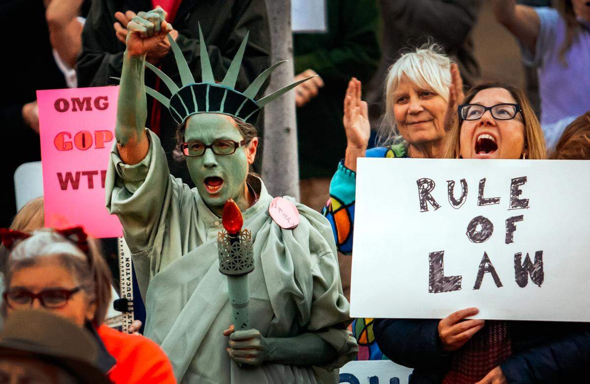 Protesters hold signs and gather Nov. 8 during a rapid response protest in San Luis Obispo, the day after President Trump forced Attorney General Jeff Sessions to resign. The action was seen by many as an attempt to impede the Russia investigation overseen by Special Council Robert Mueller.