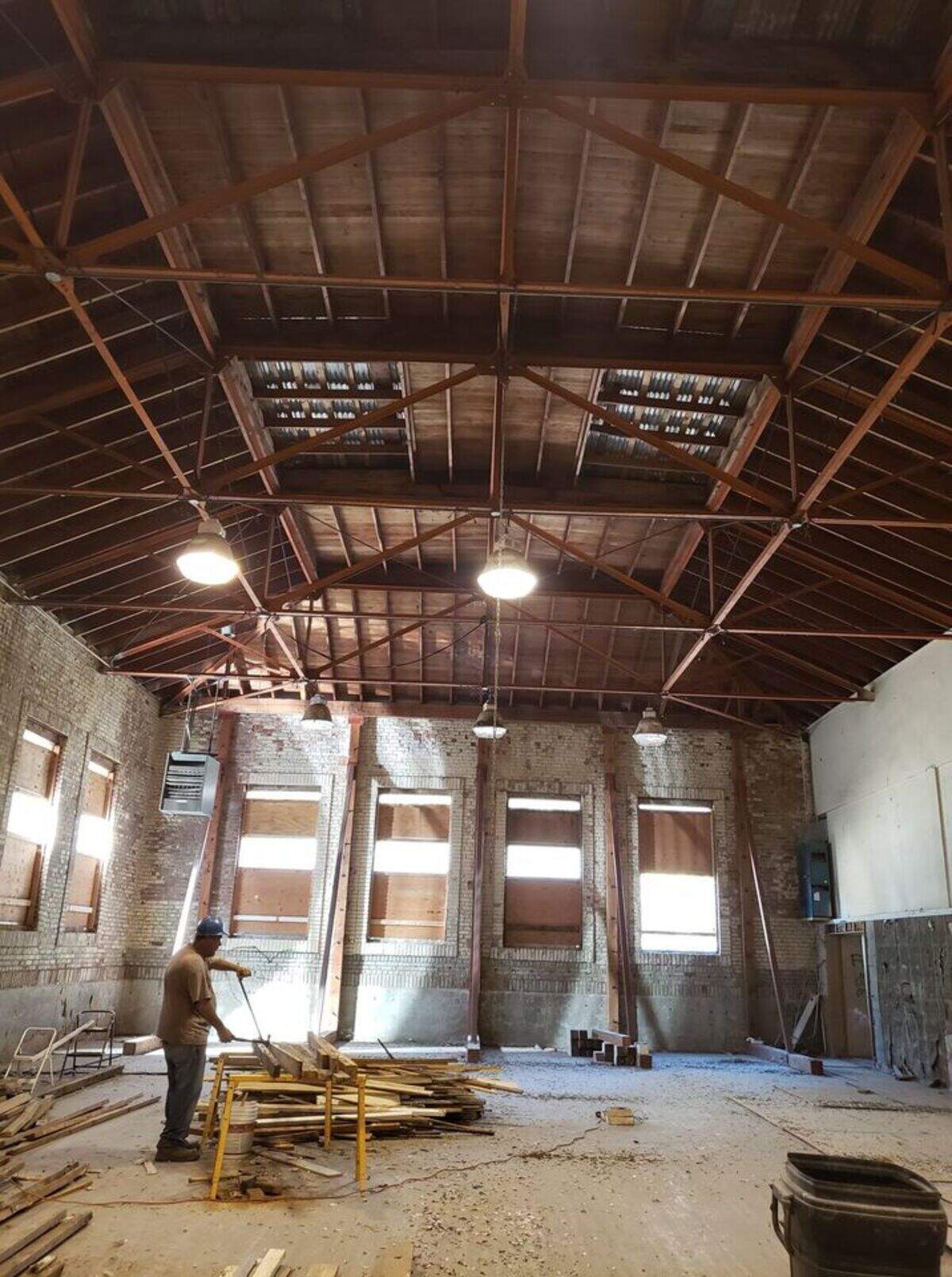 A volunteer works in the gym of the Printery, where shoring posts have been erected. The Printery Foundation is raising money to retrofit the historic Atascadero building.