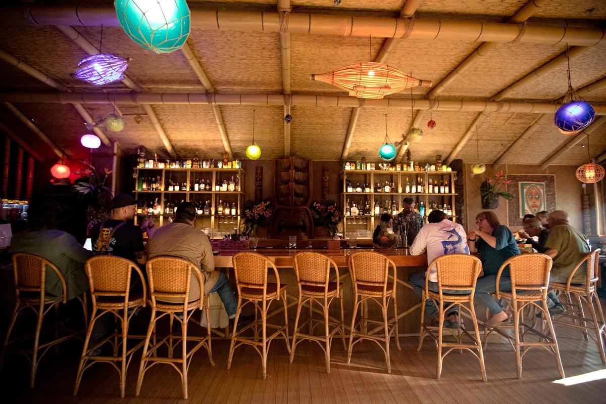Guests line up at the bar at the elaborately decorated Cane Tiki Room in Paso Robles.