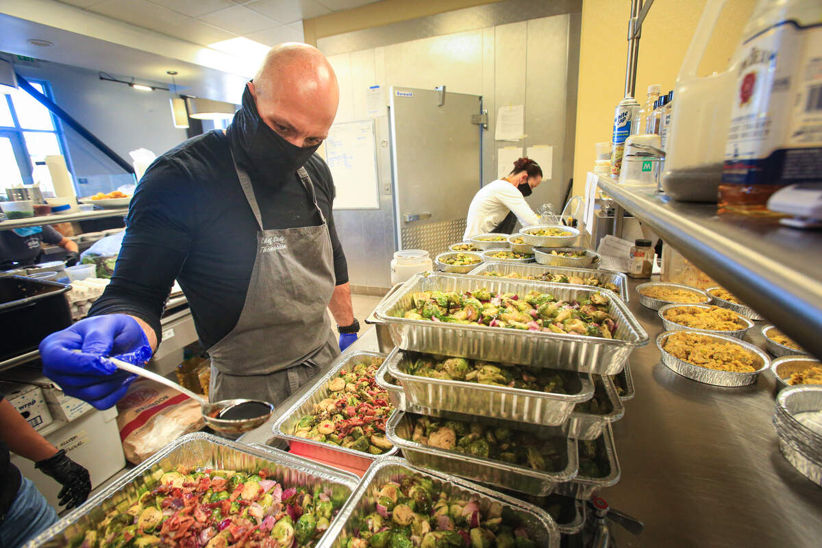 Chef Cody Thomasson puts the final touches roasted brussels sprouts. The crew at SLO Provisions worked for hours to produce ready to heat Thanksgiving meals, dishes in small and large from Brussels sprouts to turkey and gravy.