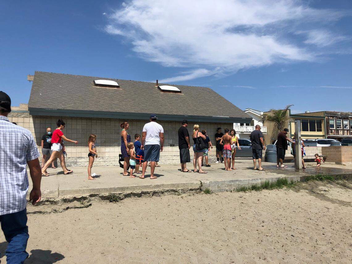 People wait in line to rinse off sand while leaving Cayucos State Beach in San Luis Obispo, California on Sunday, Aug. 16.