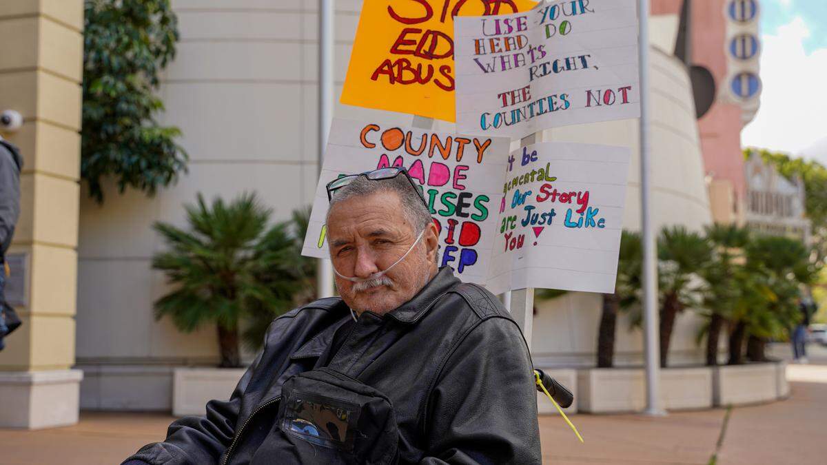 Former Oklahoma Avenue Safe Parking site resident Dave Richford holds signs during a demonstration Tuesday afternoon at the Katcho Achadjian Government Center. The San Luis Obispo County chapter of the California Homeless Union filed a lawsuit against San Luis Obispo County and the Community Action Partnership of San Luis Obispo related to the operation of the safe parking site and treatment of its residents.
