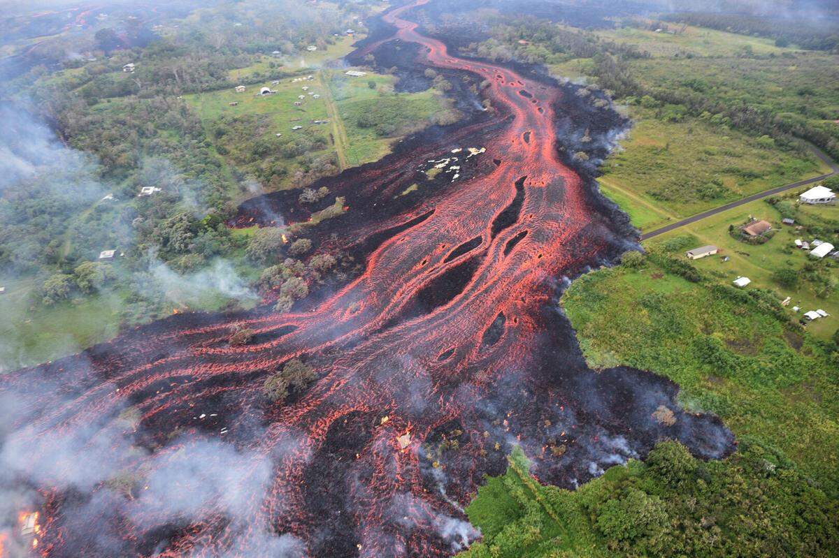 In this Saturday, May 19, 2018, photo released by the U.S. Geological Survey, lava flows from fissures near Pahoa, Hawaii. Kilauea volcano began erupting more than two weeks ago and has burned dozens of homes, forced people to flee and shot up plumes of steam from its summit that led officials to distribute face masks to protect against ash particles.