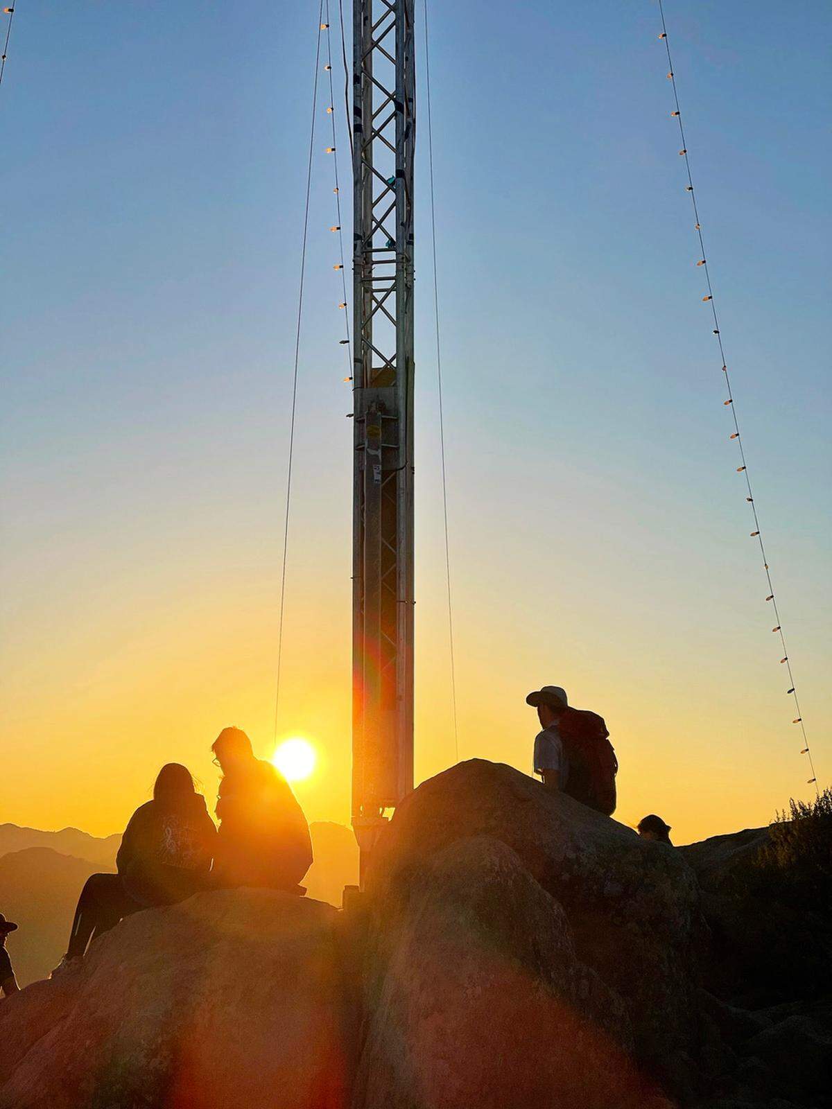 Hikers sit at the base of the lighted Christmas tree on Cerro San Luis while watching the sun set on Sunday. If you do plan a late afternoon hike to the peak, make sure you can get back down within one hour of sunset. Otherwise, you will need one of 65 night-hiking permits, which are often in high demand. For example, not a single permit remains available through Sunday of this week. If you do hike after dark without a permit, you could face a $500 fine. For more information on the night-hiking program, visit slonighthikepermit.info.