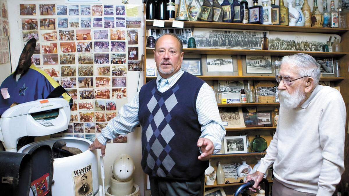 Gene Reis and son Kirk Reis pose with some of the memorabilia found in a museum beneath San Luis Obispo's Reis Family Mortuary and Crematory, including a never-used washing machine.