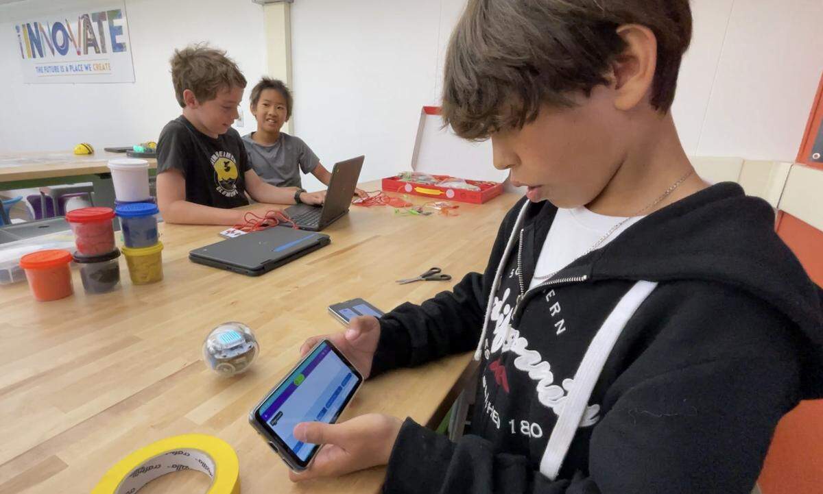 Rogellio Jr. Navarro demonstrates how he can use a special phone app to program a robot. He said he enjoys coding and hopes to continue learning about it as he grows older.