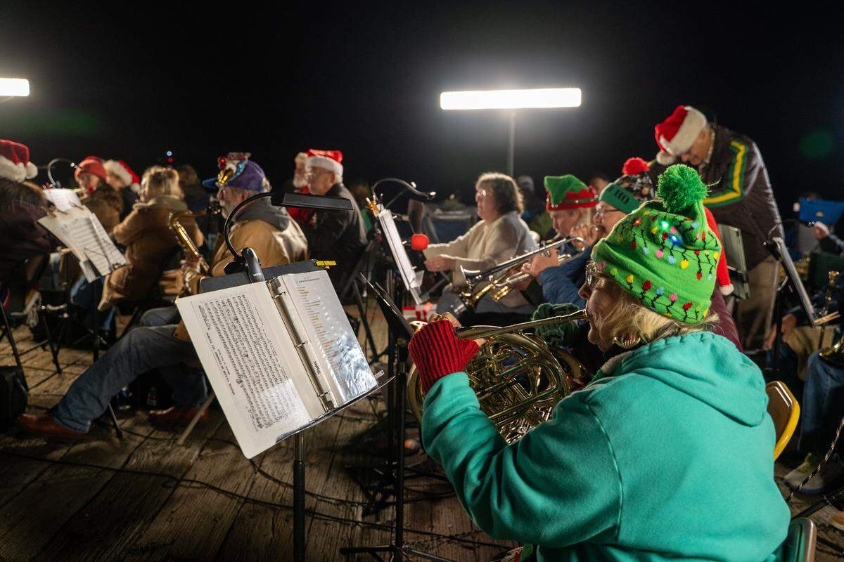 The Morro Bay White Caps Community Band plays on the pier during the Morro Bay Lighted Boat Parade on Saturday, Dec. 13, 2025. The parade drew thousands of onlookers and dozens of boats equipped with festive lighting.