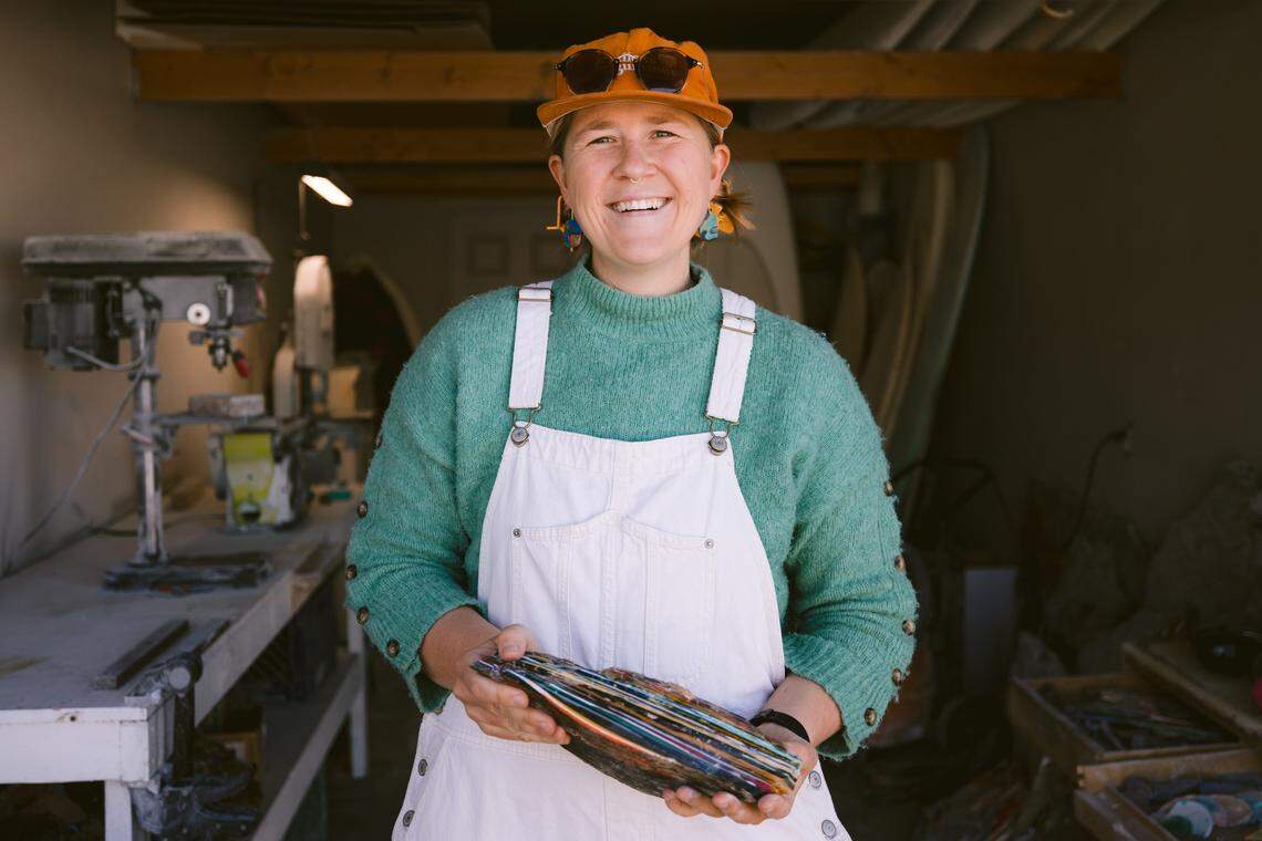 Surf Gems founder Abby Ahlgrim poses for a photo with a piece of petrified resin in her Morro Bay workshop.