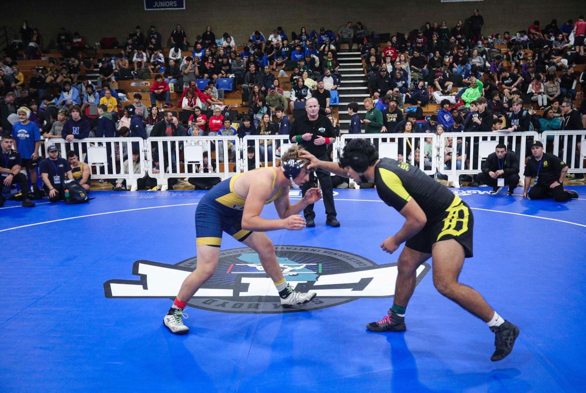 Paul Sisemore from Arroyo Grande, left, and Izaya Rubio from Delta High School spar in the 190-pound weight class as referee Dan Duclos watches. Over 900 wrestlers from across California came to Morro Bay to attend the California Invitational Tournament on Jan. 19, 2024.