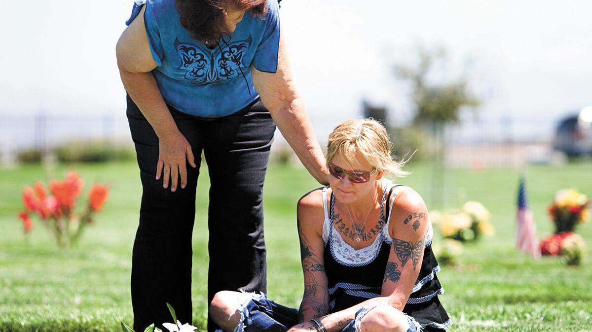 Dystiny Myers' mother, Aileen Myers, right, and grandmother, Kathy Clark, share a quiet moment while visiting Dystiny's gravesite at the Santa Maria Cemetery.