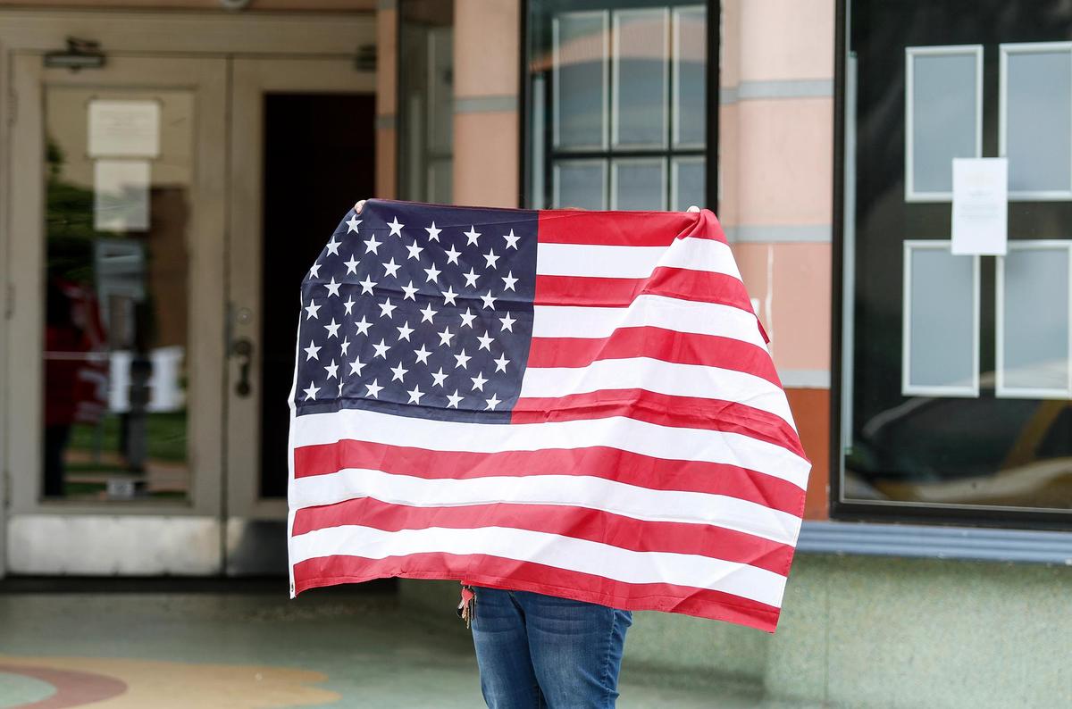 This woman was holding a flag in front of the Fremont. A small group of citizens protest the coronavirus shutdown in front of the San Luis Obispo County Courthouse, Sunday, April 26, 2020.