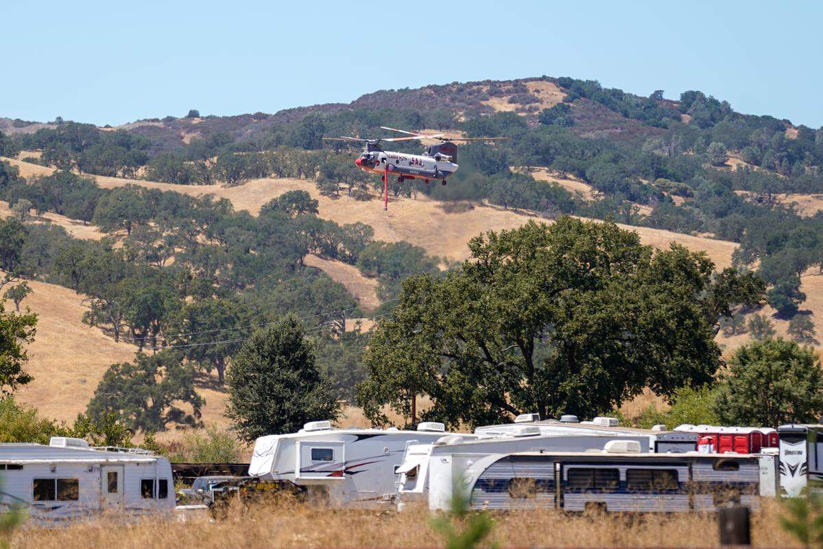 A water dropping helicopter returns to fire camp outside Santa Margarita on Wednesday, Aug. 13, 2025.