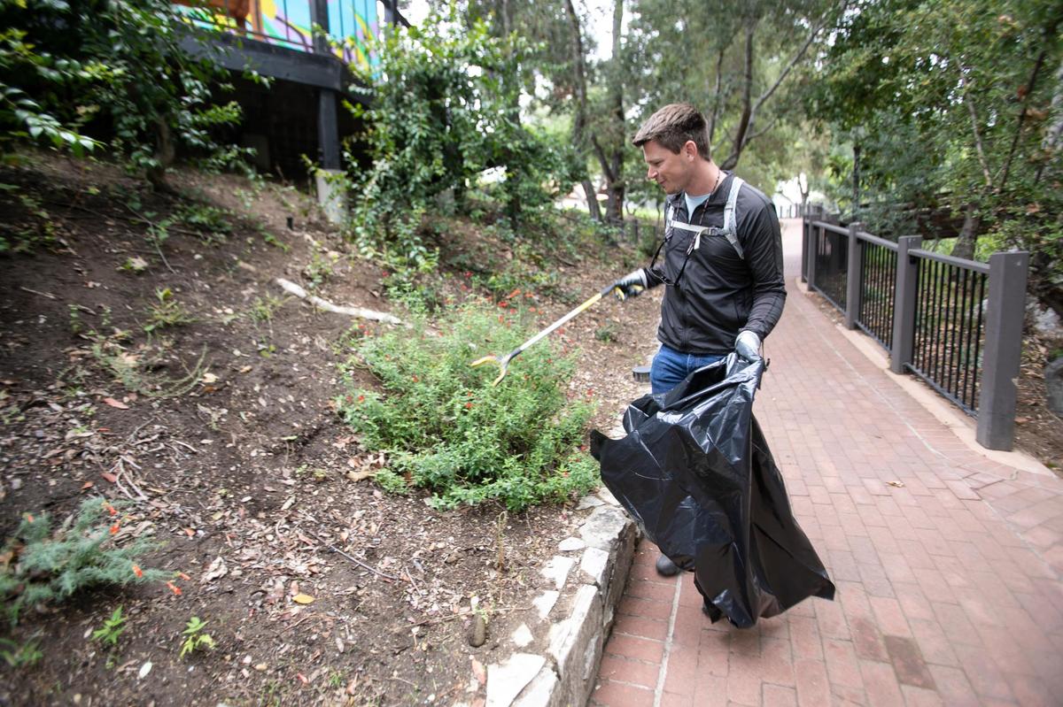 Matt Irons, of San Luis Obispo, cleans around the walkway at San Luis Creek downtown on Sept. 17, 2022.