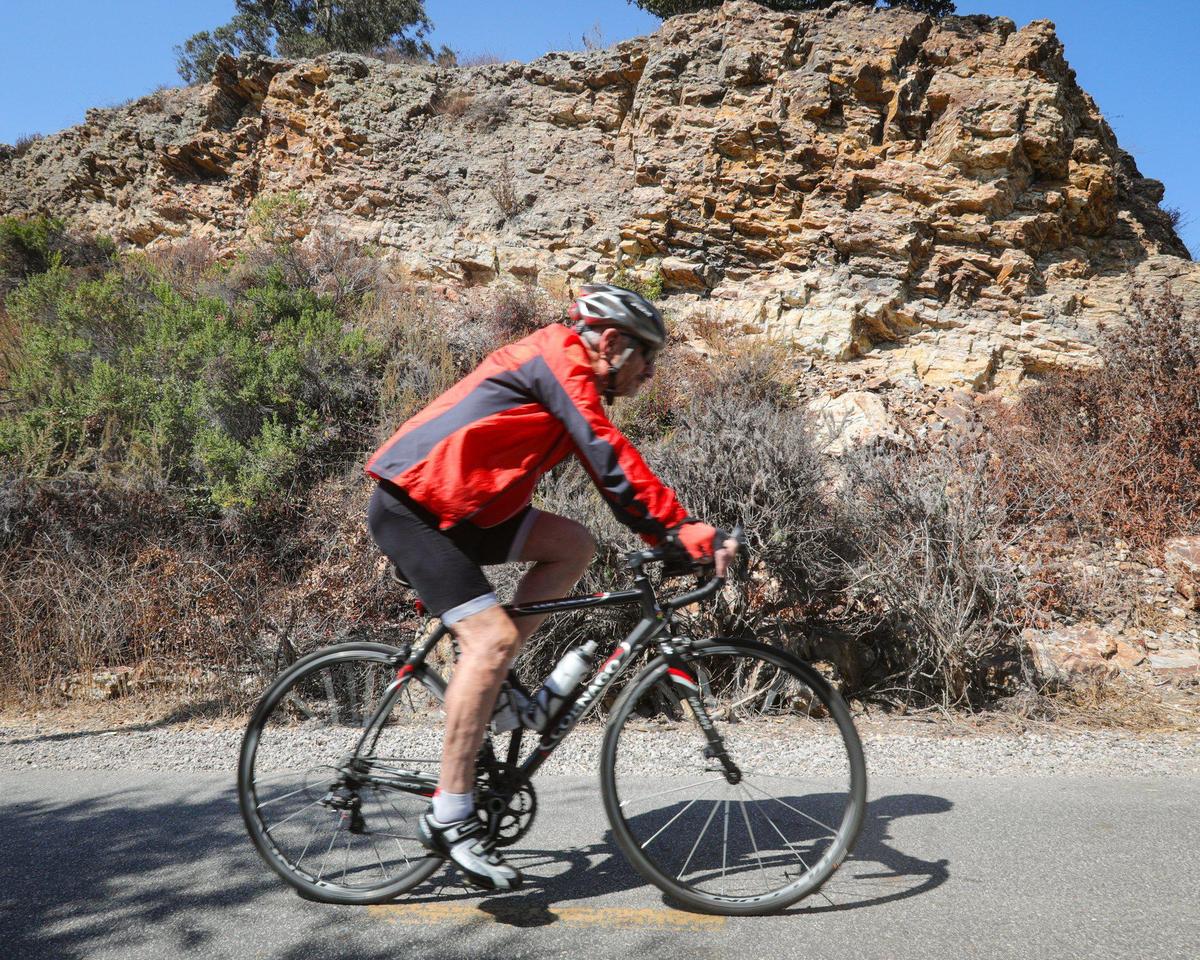 A cyclist glides by fossil-filled Monterey shale on the Bob Jones Trail on Sept. 22, 2023. The county wants to complete the trail from Avila Beach to San Luis Obispo but now will likely need to alter the route around at least one property whose owner has refused to sell a sliver of his land.