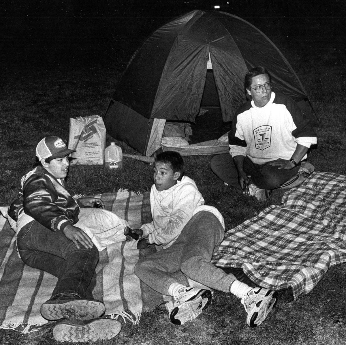 Damage in Hollister in the wake of the Loma Prieta Earthquake. From the left Steve Silva,15, John Bocanegra Jr. 13, and his father wait outside their home, waiting out aftershocks and avoiding the broken glass inside Oct. 17, 1989.