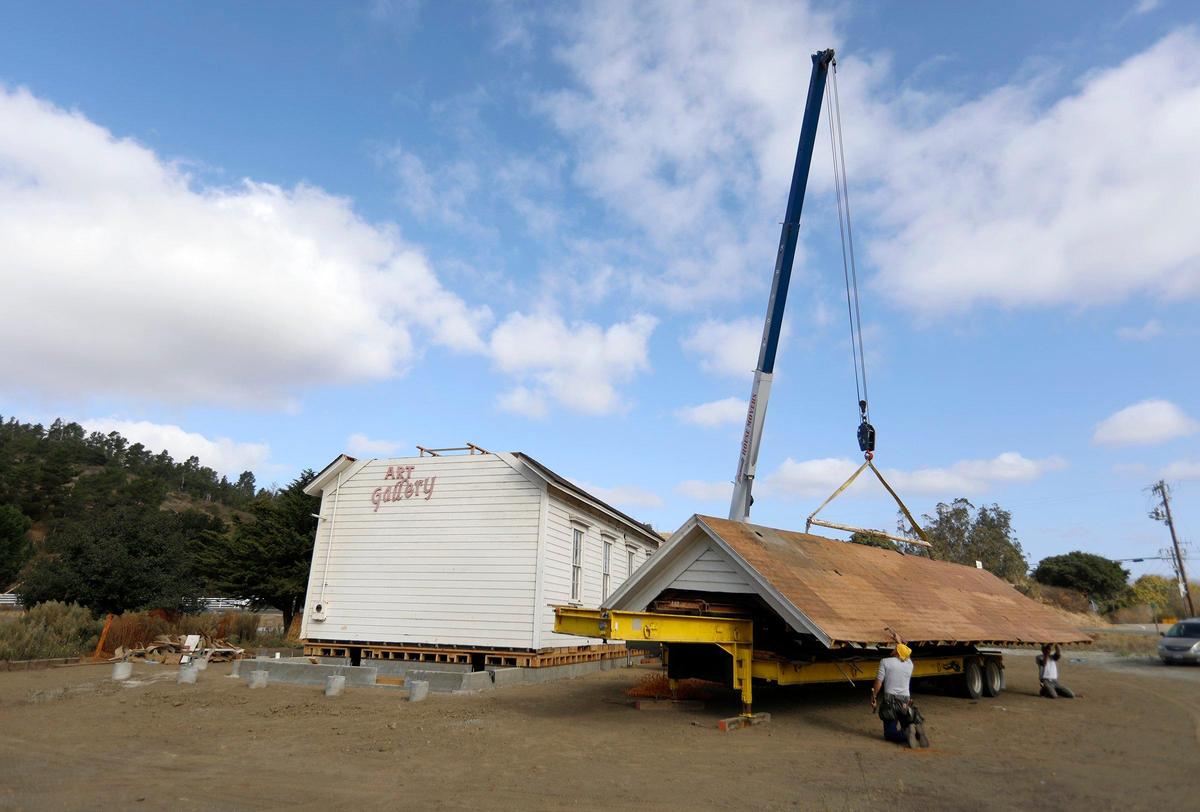 Cambria Historical Society’s Old Santa Rosa Schoolhouse was moved to a meadow on Main Street at Santa Rosa Creek Rd. A large crane was used by Brandt House and Building Movers to gingerly place the roof back on. Crewmen get the roof ready to be pulled up by the crane.