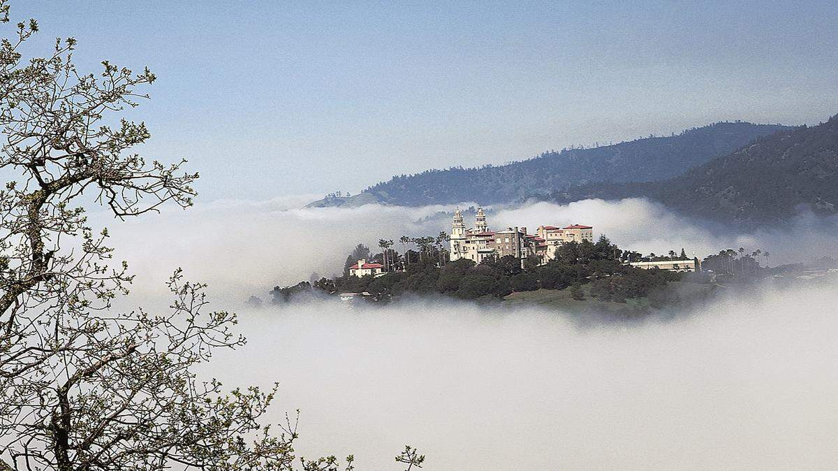 Fog swirls around Hearst Castle in the hills above San Simeon.