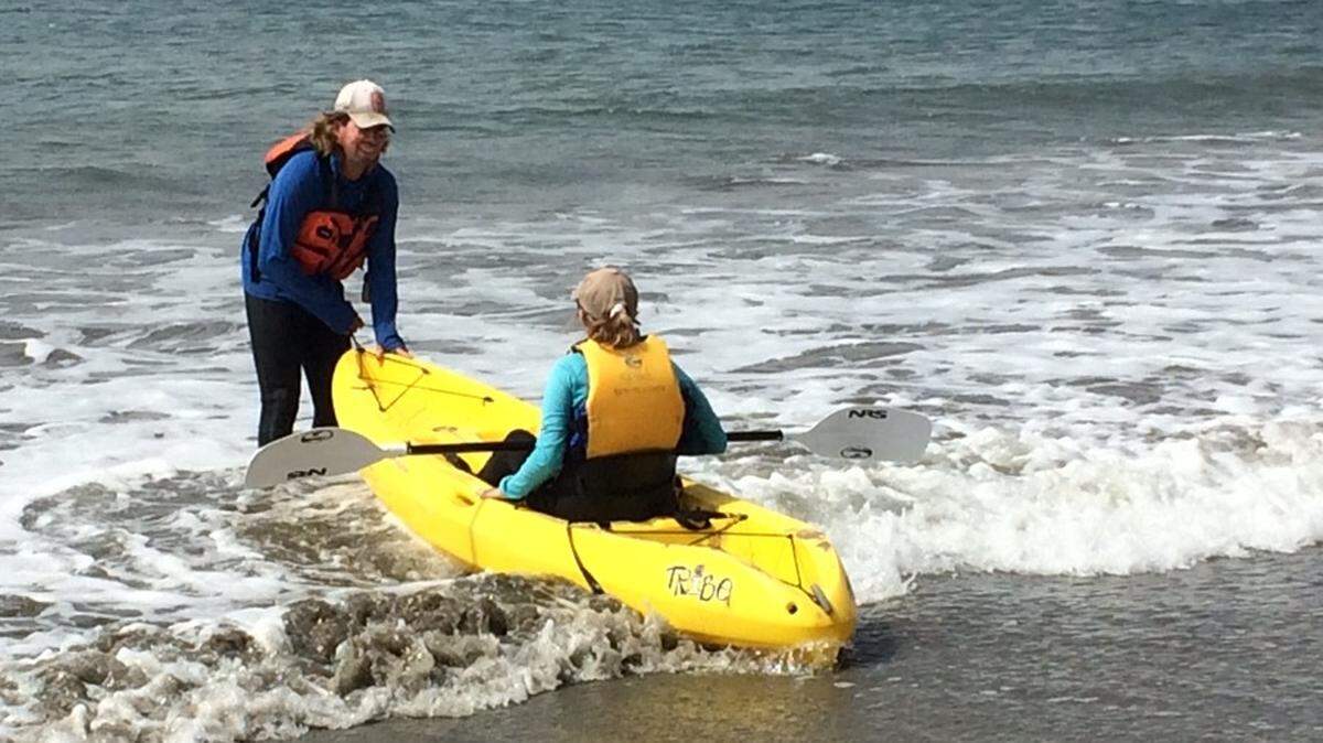 San Simeon Cove kayak rental owner Cubby Cashen helps customers get their kayaks safely launched into the cove.